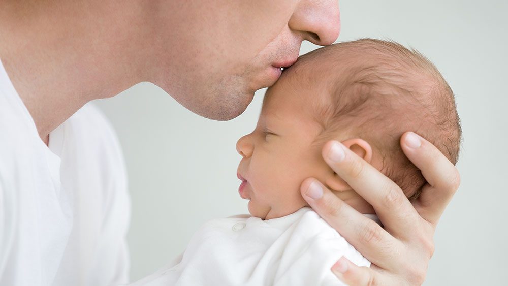 Person kissing baby on forehead