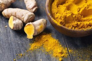 Powdered and whole turmeric root. One of the powerful herbs for a healthy liver