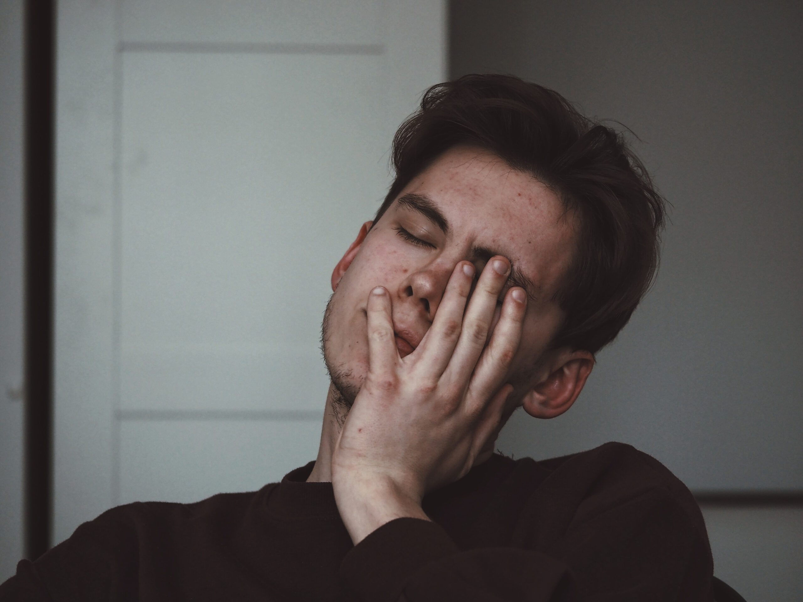 Person with their head in their hand, as if they had a headache.