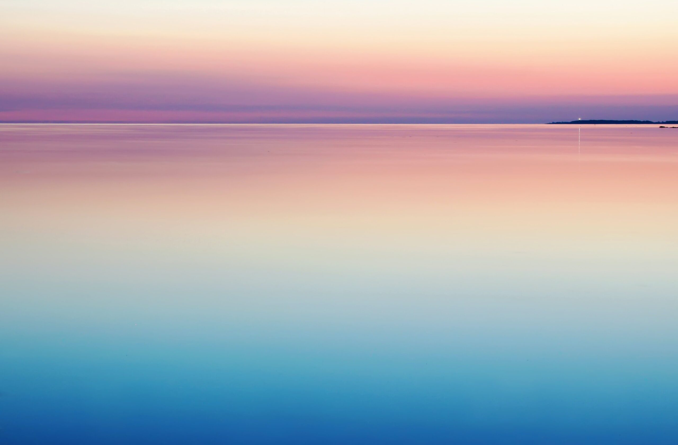 Colorful sunrise/sunset against water.