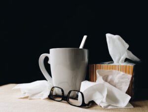 Box of tissues, mug, and glasses on table. Women's Health From a Natural Perspective