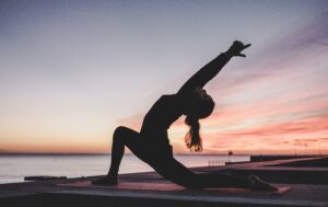 Person doing yoga with sunset background