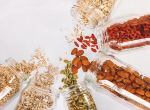 Various nuts, seeds, and fruits: crushed walnuts, sunflower seeds, pumpkin seeds, almonds, and goji berries