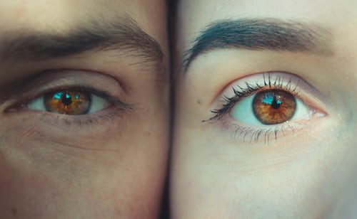 Eye Health. 2 people looking forward at the camera with their faces touching
