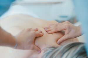 Massaging upper back with both hands